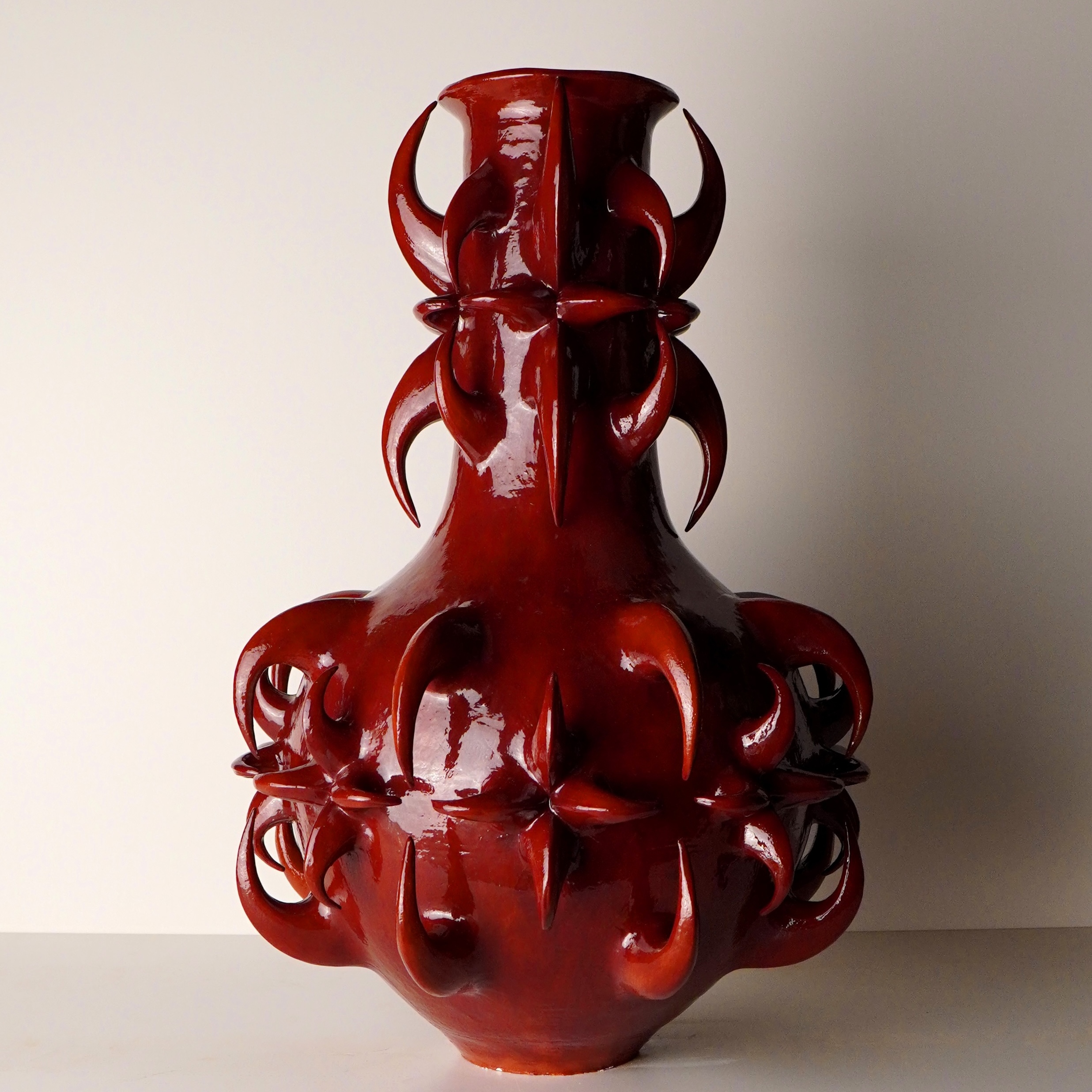 Glossy deep-red sculptural ceramic vessel with looping thornlike forms by Jeung Hoon Nam